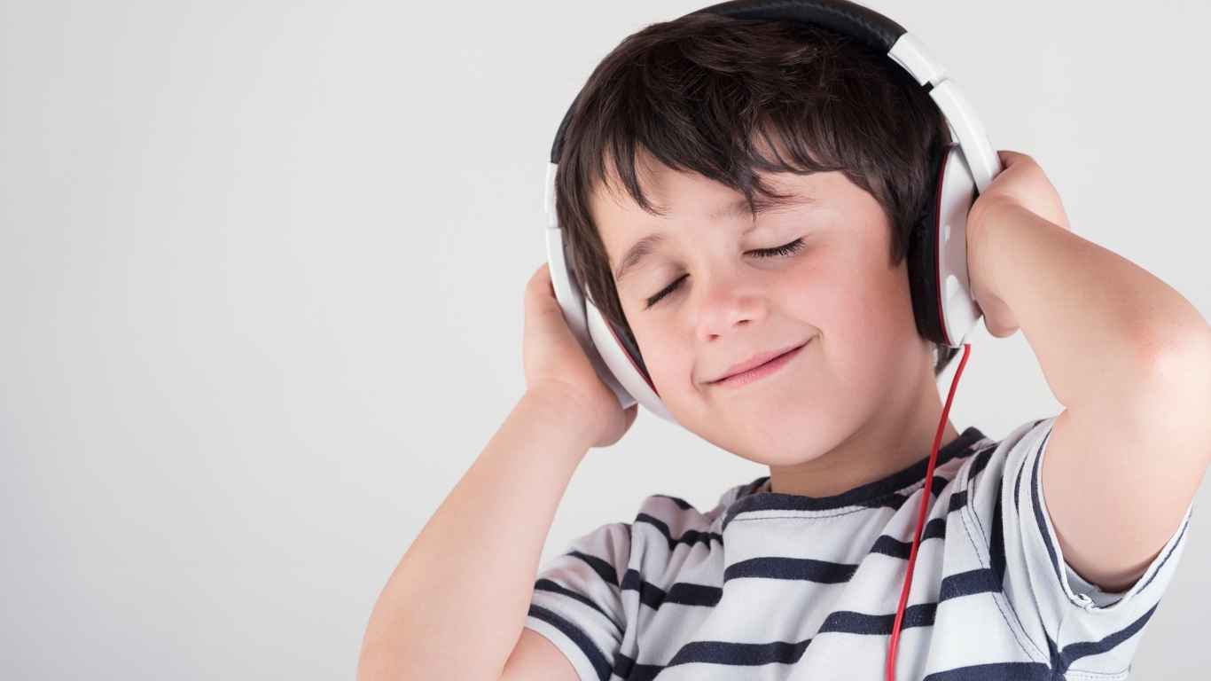 Kind hört englische Lieder und Geschichten beim Spielen zu Hause
